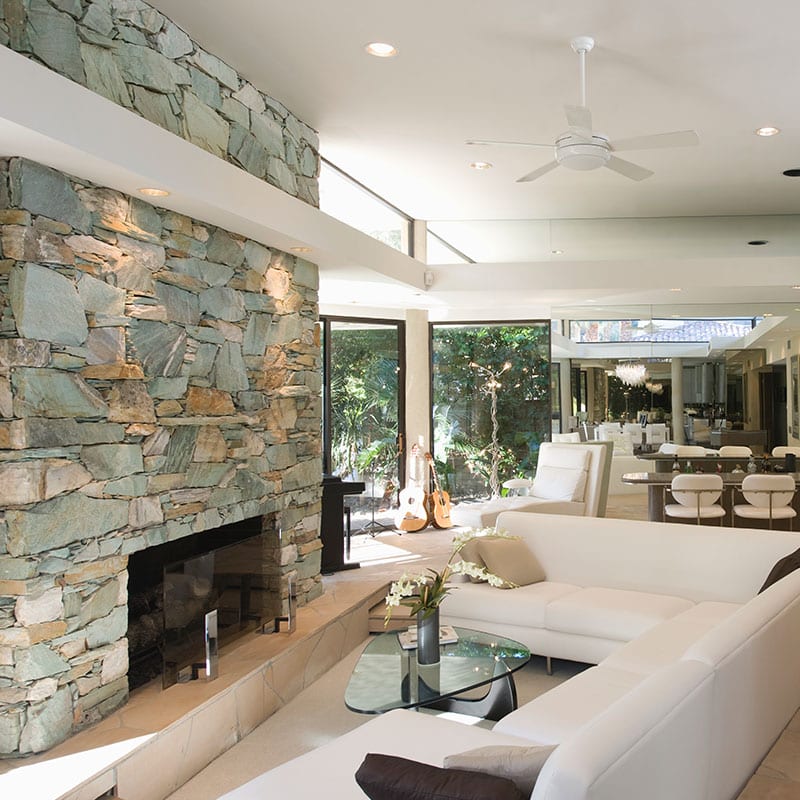 Vaulted great room with a floor-to-ceiling stacked stone fireplace