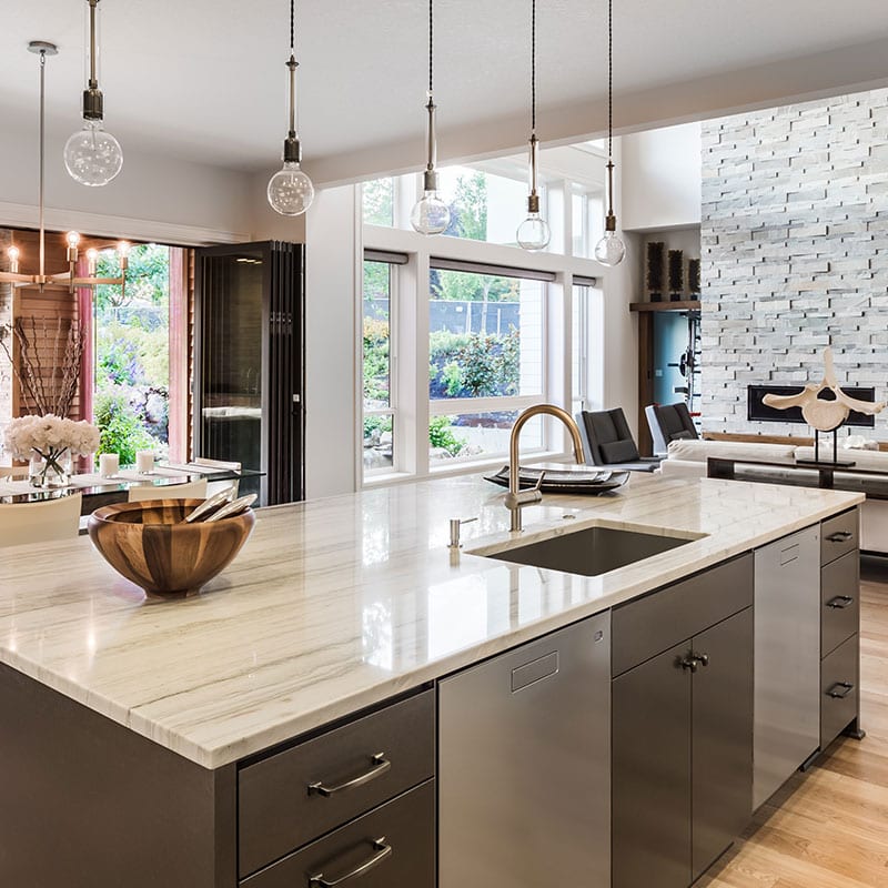Modern kitchen with a marble-topped island, undermount sink and pendant lighting