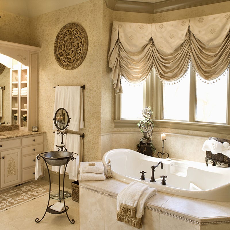 Renovated bathroom with a tiled soaking tub deck and stone-topped vanity