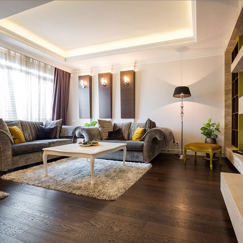 Living room with dark hardwood flooring, a tray ceiling and recessed lighting